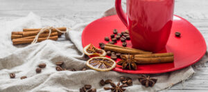 red coffee Cup on a plate, on a beautiful white wooden background, beverage, Christmas morning, a lot of decoration,